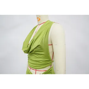 Close-up detail showing the texture of a green halter cowl neck top on a dress form