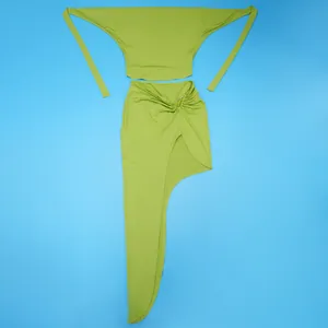 Detail shot of a lime green two-piece set featuring a halter top and asymmetrical slit skirt