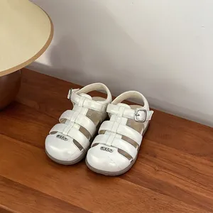 Close-up of white pearl finish baby girl walking sandals with closed-toe design