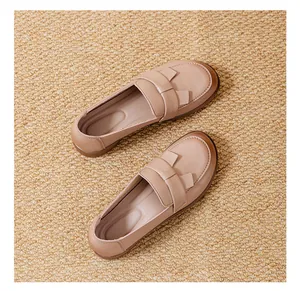 Λεπτομέρεια από κομψά μπεζ vintage loafers με φιόγκο σε φυσική υφαντή ψάθα