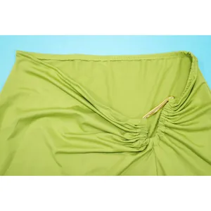 Macro detail of sexy lime green draped fabric featuring elegant gold metallic hardware.