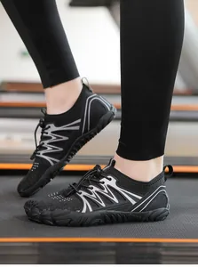 Nahaufnahme schwarzer schnelltrocknender Barfußschuhe mit Reflexstreifen auf Laufband