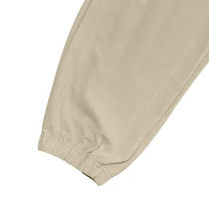 Detailed macro view of elasticized ankle cuff on khaki men's linen jogger pants