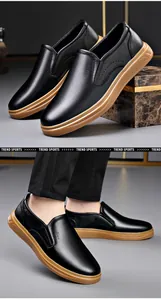 Men's black slip-on leather loafers with brown rubber soles for business and driving.