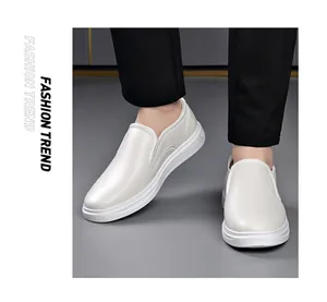 Close-up detail of white men's leather slip-on loafers worn with black dress pants