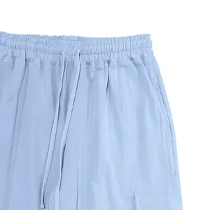 Detail shot of light blue linen cargo pants featuring elastic waistband and drawstring.