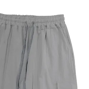 Detailed view of grey linen cargo pants showing elastic waistband and drawstring.