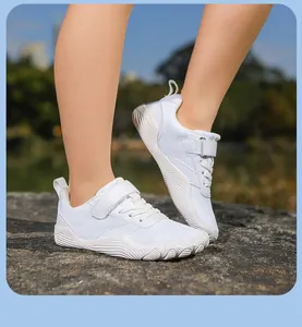 Child wearing white breathable barefoot-style minimalist shoes in an outdoor setting