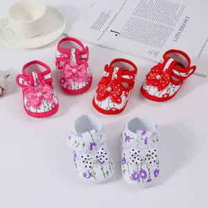 Detailed view of soft-sole floral baby sandals with polka dot bows and pearl accents.