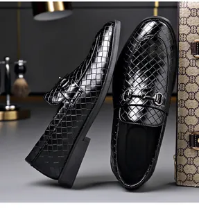 Detail macro view of black men's loafers with woven texture and horsebit buckle decoration