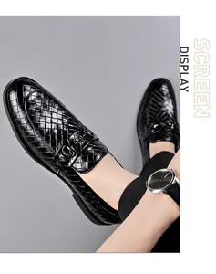 Close-up of black woven leather loafers with metallic double buckle detail