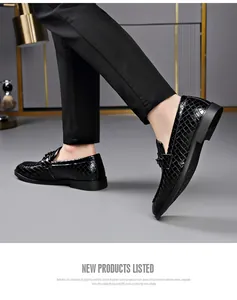 Detailed view of men's black crocodile embossed loafers in a business attire setting