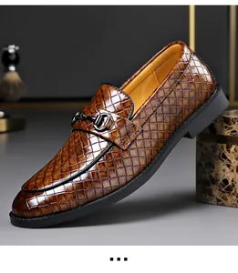 Detail view of a stylish brown crocodile texture men's loafer with metallic horsebit buckle