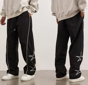 High street men's black sports pants with white star embroidery, front and back view