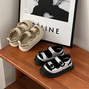 Close-up of stylish children's closed-toe summer sandals in beige and metallic silver tones
