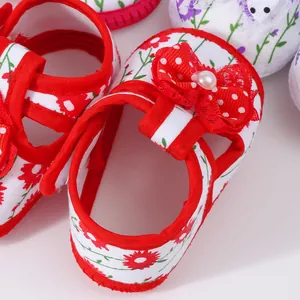 Detailed view of baby floral sandals with a red polka dot bow and soft white insole