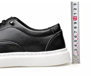 Gros plan de chaussures en cuir noir à semelles épaisses mesurant la hauteur du talon.
