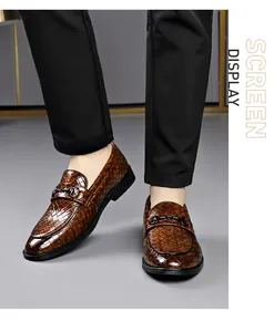 Close-up of brown crocodile pattern men's loafers with horsebit buckle detail