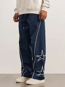 Detail of navy blue high-street sports pants with white star patterns and piping design
