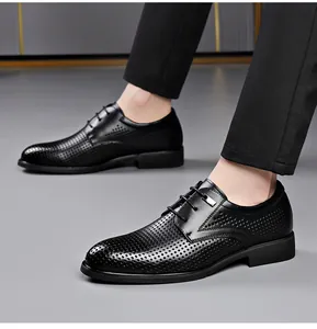 Macro view of men's breathable black hollow leather business dress shoes on model feet