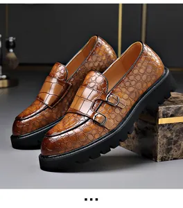 Detail van bruine herenloafers met krokodillenmotief en dikke profielzool.