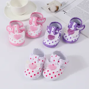 Detailed view of baby girl soft-sole polka dot sandals with glittery heart and wing motifs