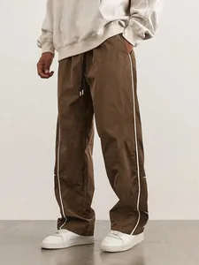 Men's brown high street track pants with white side stripes and drawstring waist.