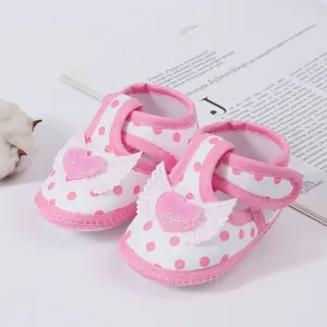 Pink polka dot baby girl sandals with heart wing detail for toddlers.
