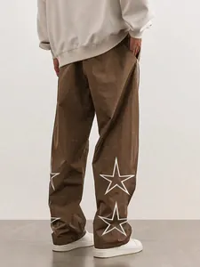 Brown high-street joggers featuring large white star embroidery on lower legs