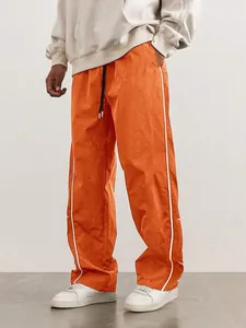 Vibrant orange men's high street track pants with white side stripes and loose fit.