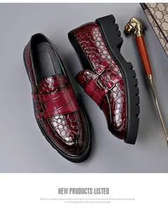 Detail van bordeauxrode loafers met krokodillenprint en dubbele gespbanden op zool