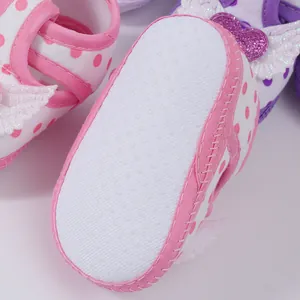 Detailed macro view of the anti-slip soft sole on baby girls pink polka dot walking sandals