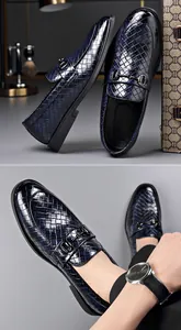 Detail macro view of men's navy blue woven leather loafers with elegant metal bit buckle