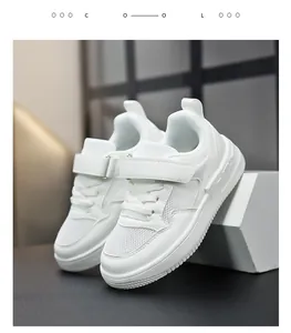 Vue détaillée des baskets blanches pour enfants avec fermeture velcro et tige en cuir