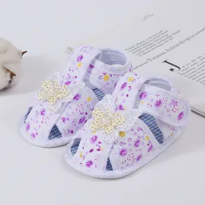 Detail view of baby girl floral sandals with cute butterfly and pearl accents.