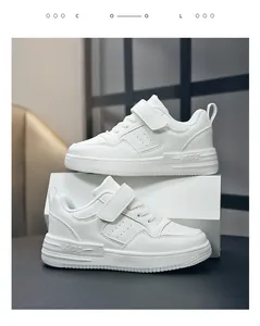 Gros plan de baskets en cuir blanc pour enfants avec bride velcro et logo KIDS.