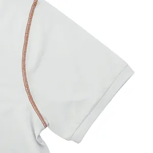 Detailed view of white men's polo shirt sleeve featuring brown contrast stitching accents.