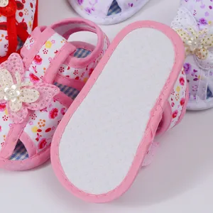 Detail of infant girl floral sandals with non-slip sole and butterfly decoration