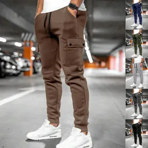Multi-color men's cargo joggers in various shades shown in an urban garage setting