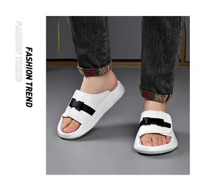 White men's slides with black buckle detail worn with dark jeans