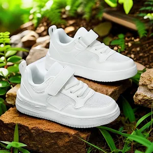 Baskets de sport respirantes en cuir blanc pour enfants avec velcro dans un jardin