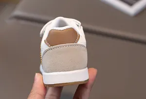 Close-up detail of the heel on children's white and brown PU leather casual sneakers.