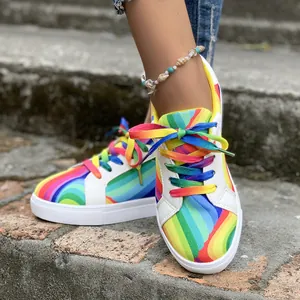 Close-up of vibrant rainbow gradient pattern and laces on women's casual sneakers.