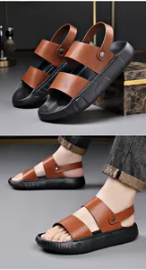 Detail van bruine leren herensandalen met dikke zwarte zolen, zijaanzicht en gedragen op de voet.