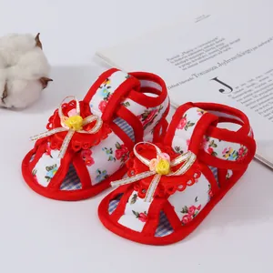 Close-up view of floral print baby girl sandals featuring soft soles and ribbon accents.