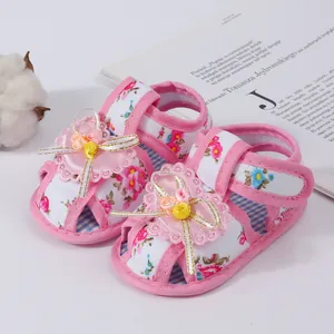 Close-up of pink floral baby girl sandals with soft breathable soles and cute ribbons