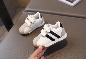 Lässige weiße Kinderschuhe im Freizeitstil mit schwarzen Streifen und Klettverschluss