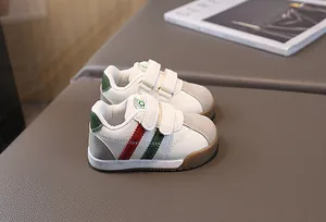 Detail of toddler PU leather walking sneakers with red and green stripes and velcro straps.