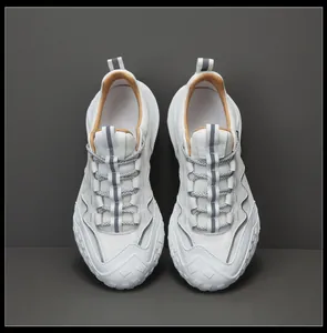 Vue de dessus de baskets de randonnée en cuir blanc pour hommes sur fond gris.