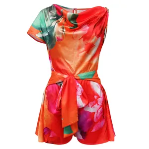 Detail of vibrant floral print romper featuring a stylish slanted neck and waist tie